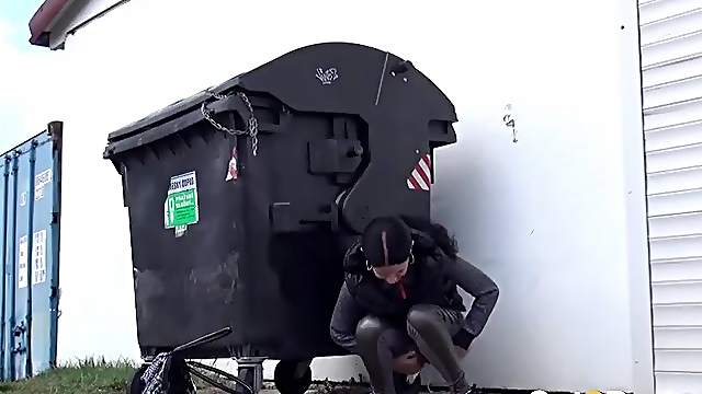 Shiny leggings girl pees behind a dumpster