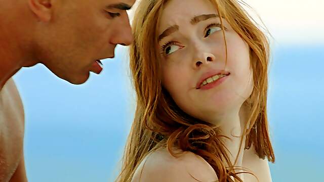 A couple enjoys passionate sex under the open sky with a stunning redhead.