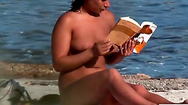 Curvy naked amateur rubs in tanning oil at the beach