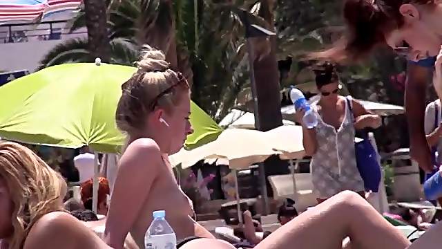 Beach blonde listens to music with her tits outd